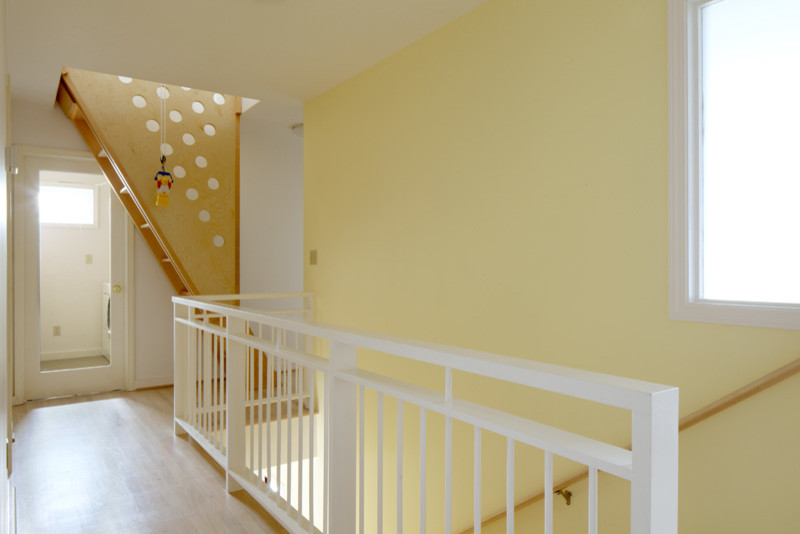 Inspiration pour un couloir traditionnel de taille moyenne avec un mur jaune et parquet clair.