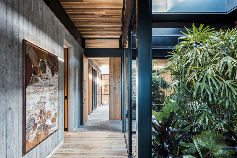 Ispirazione per un ingresso o corridoio minimal con pareti grigie, pavimento in legno massello medio e pavimento marrone