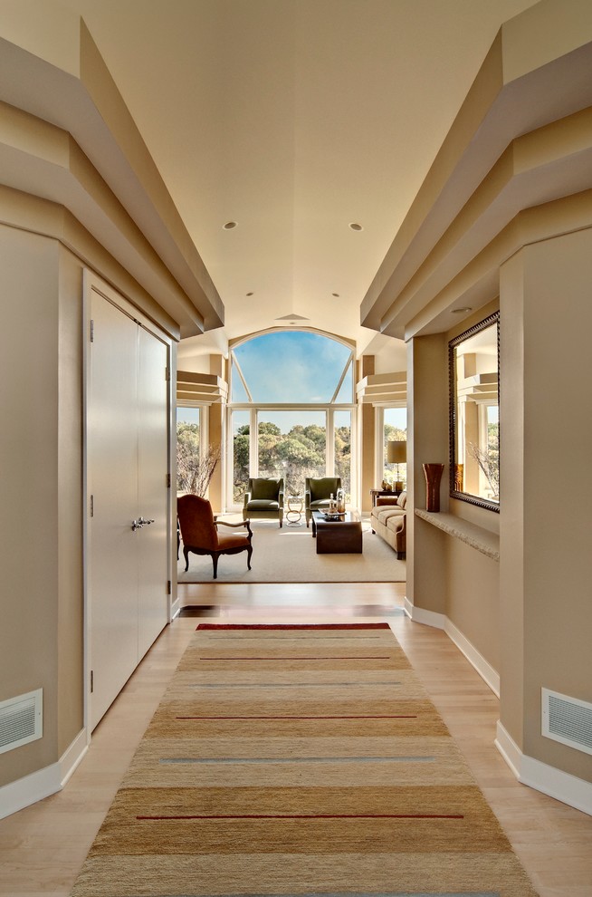 Modelo de recibidores y pasillos clásicos renovados grandes con paredes beige y suelo de madera clara
