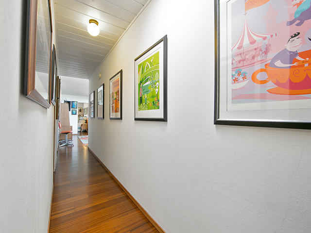 Inspiration pour un couloir vintage de taille moyenne avec un mur blanc et un sol en bois brun.