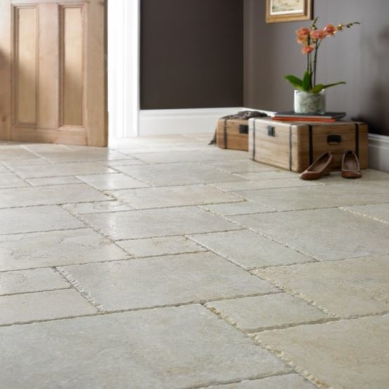 Example of a large limestone floor hallway design in Other with beige walls