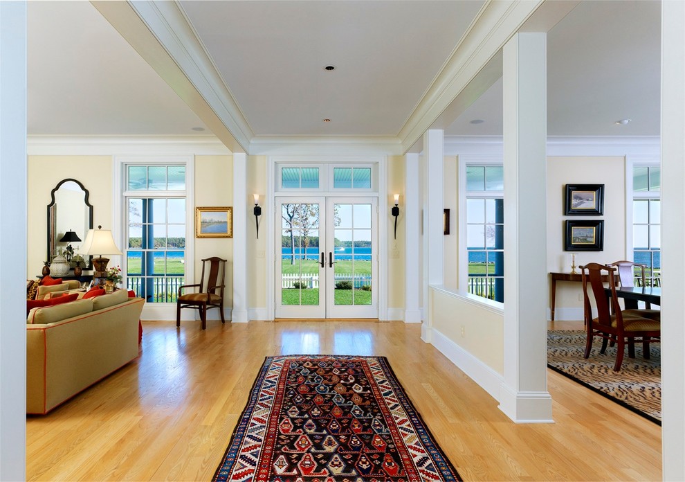Example of a large country light wood floor hallway design in DC Metro with beige walls