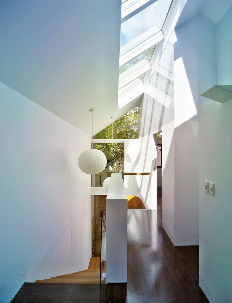 Example of a trendy medium tone wood floor hallway design in Sydney with white walls