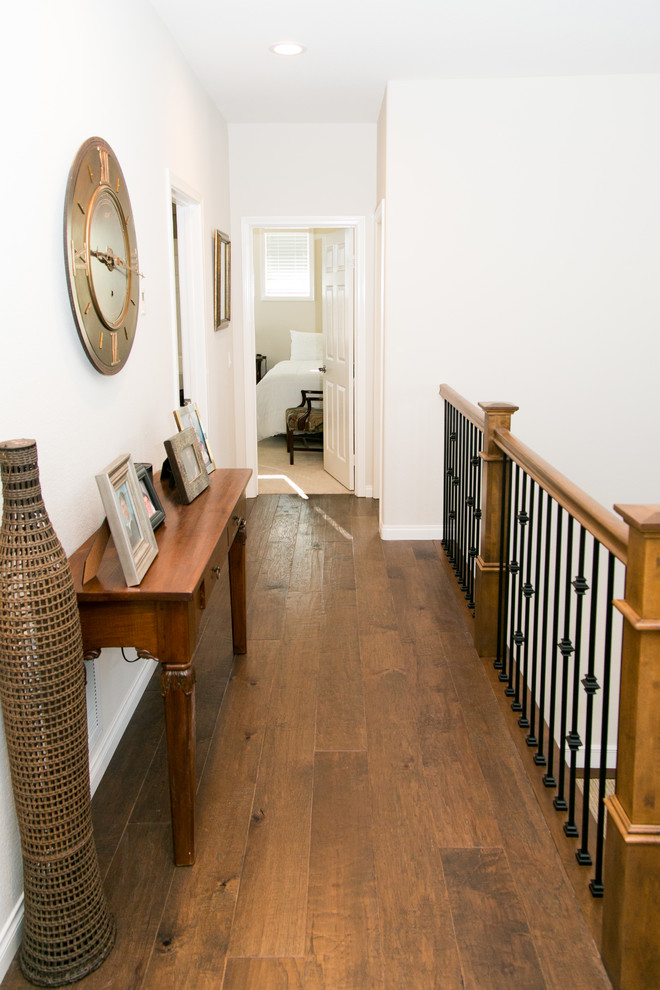 Exemple d'un couloir chic de taille moyenne avec un mur beige et un sol en bois brun.