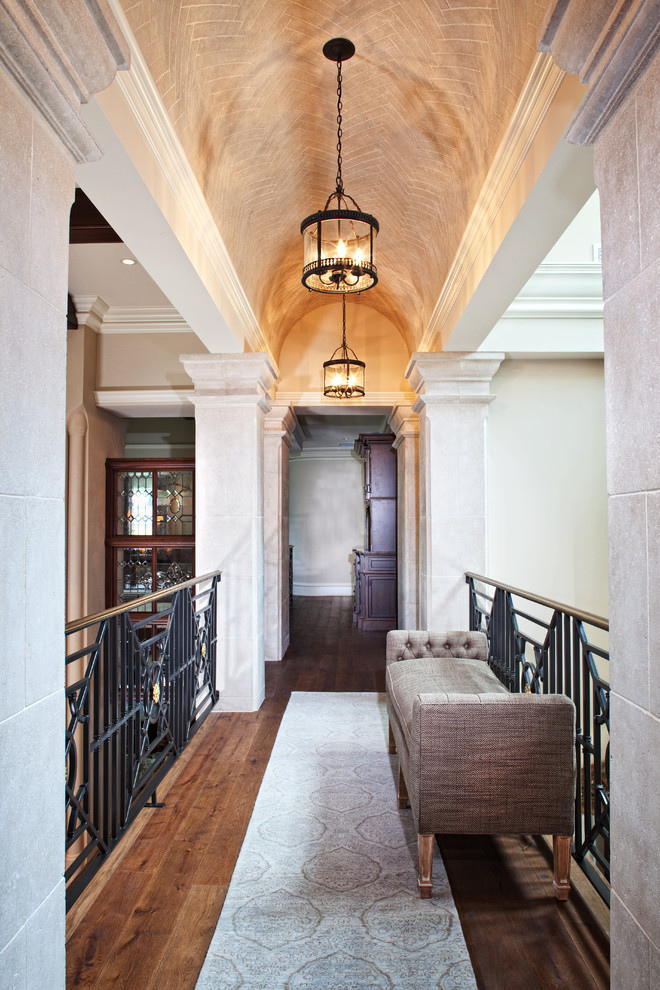 Diseño de recibidores y pasillos clásicos grandes con paredes beige y suelo de madera oscura