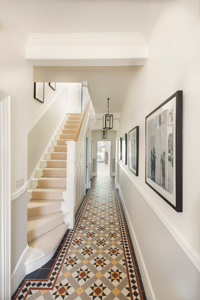 Идея дизайна: большой коридор в стиле неоклассика (современная классика) с белыми стенами, полом из керамической плитки и разноцветным полом
