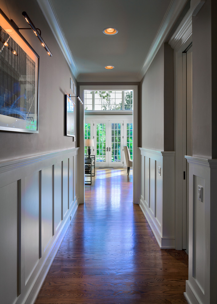 Immagine di un grande ingresso o corridoio american style con pareti beige e pavimento in legno massello medio