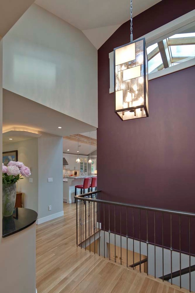 Esempio di un ingresso o corridoio minimal di medie dimensioni con pareti viola e parquet chiaro