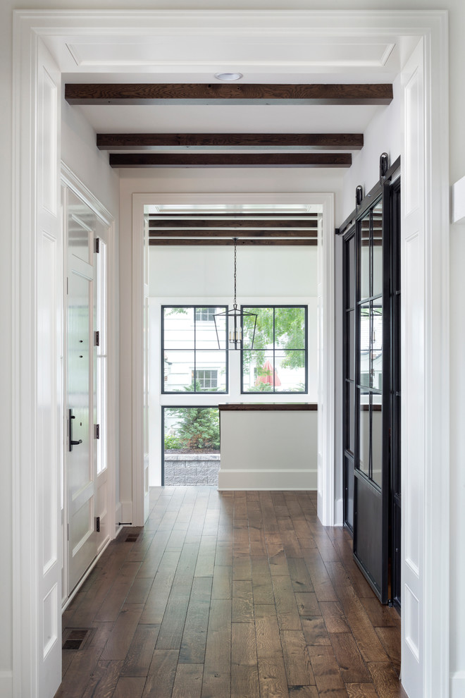 Ispirazione per un grande ingresso o corridoio chic con pareti bianche, pavimento marrone e pavimento in legno massello medio