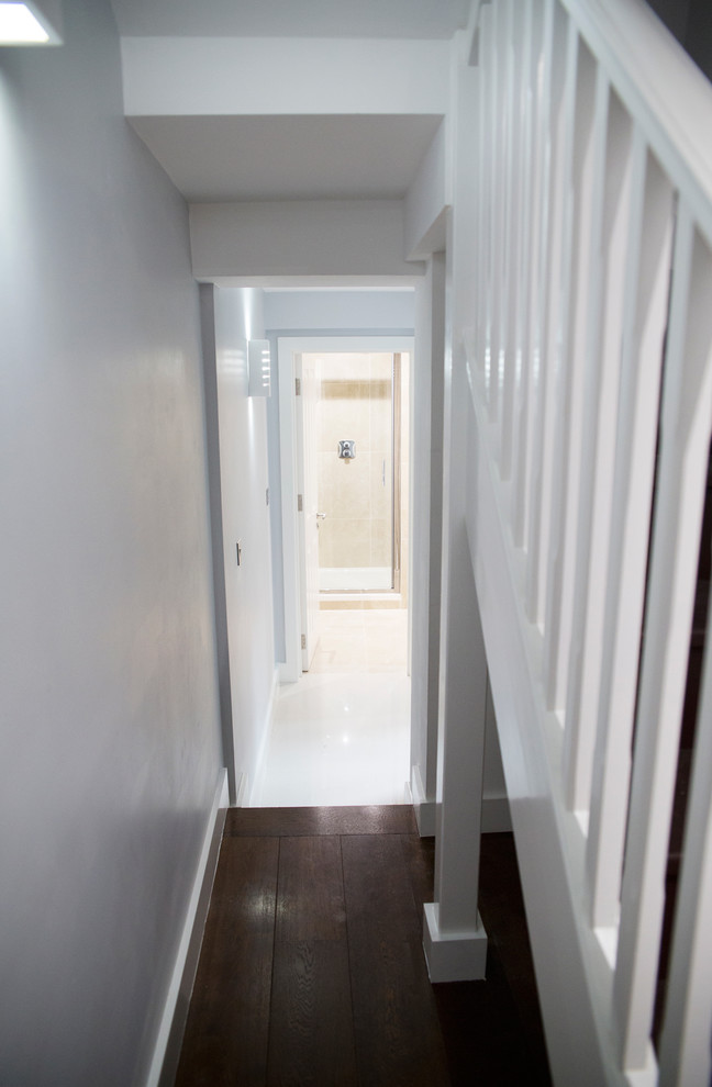 Réalisation d'un petit couloir design avec un mur blanc, parquet foncé et un sol marron.