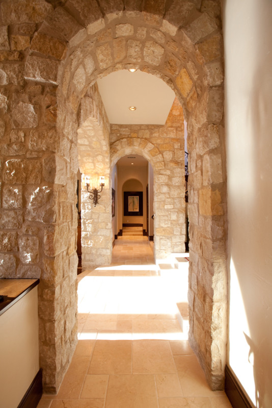Example of a large tuscan hallway design in Austin with beige walls
