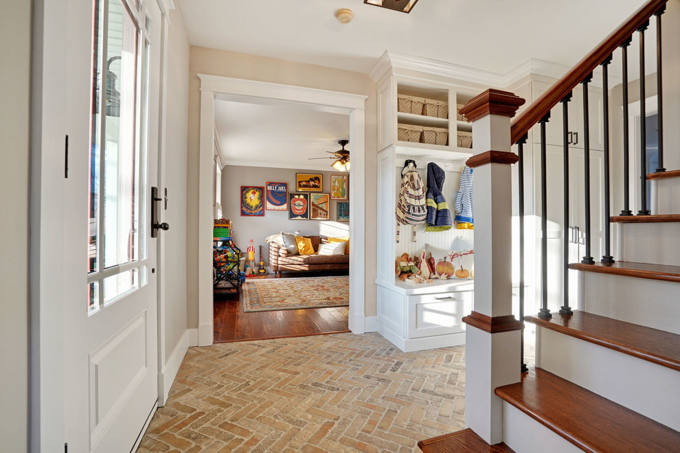 Inspiration pour un grand couloir craftsman avec un mur beige, tomettes au sol et un sol marron.