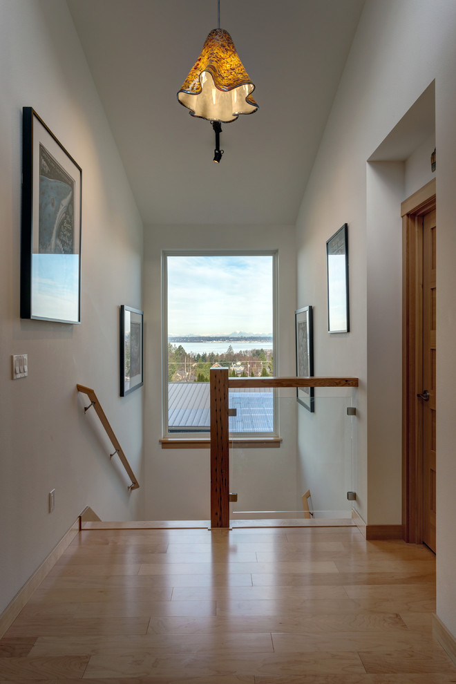 Hallway - mid-sized modern light wood floor and brown floor hallway idea in Seattle with white walls