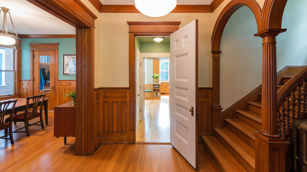 Modelo de recibidores y pasillos tradicionales con paredes beige y suelo de madera en tonos medios
