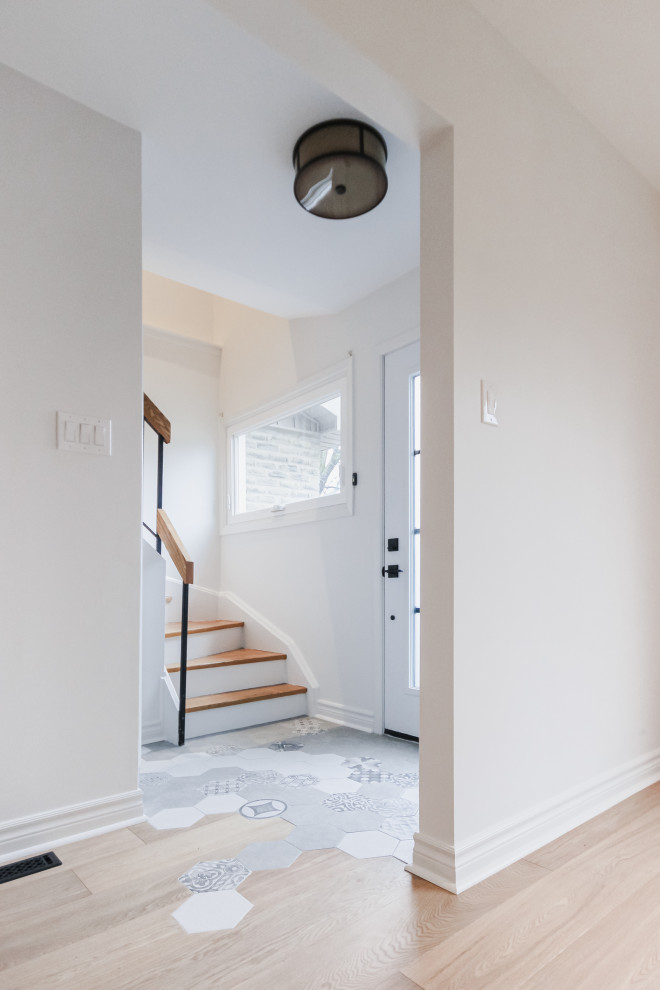 Immagine di un piccolo ingresso o corridoio scandinavo con pareti bianche, pavimento in gres porcellanato e pavimento grigio