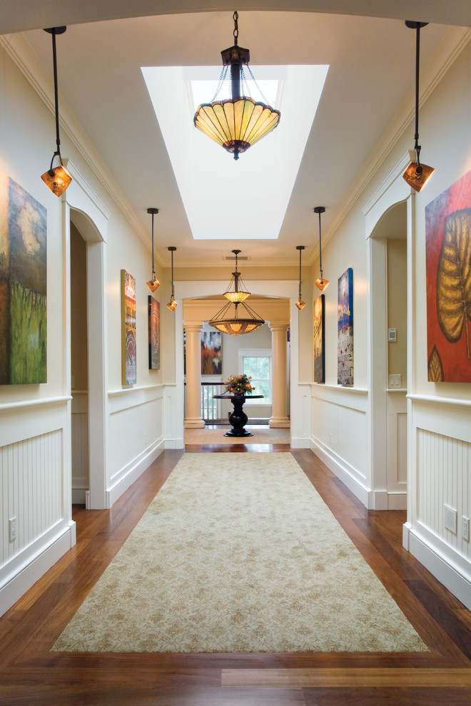 Cette image montre un couloir traditionnel avec un mur beige et parquet foncé.