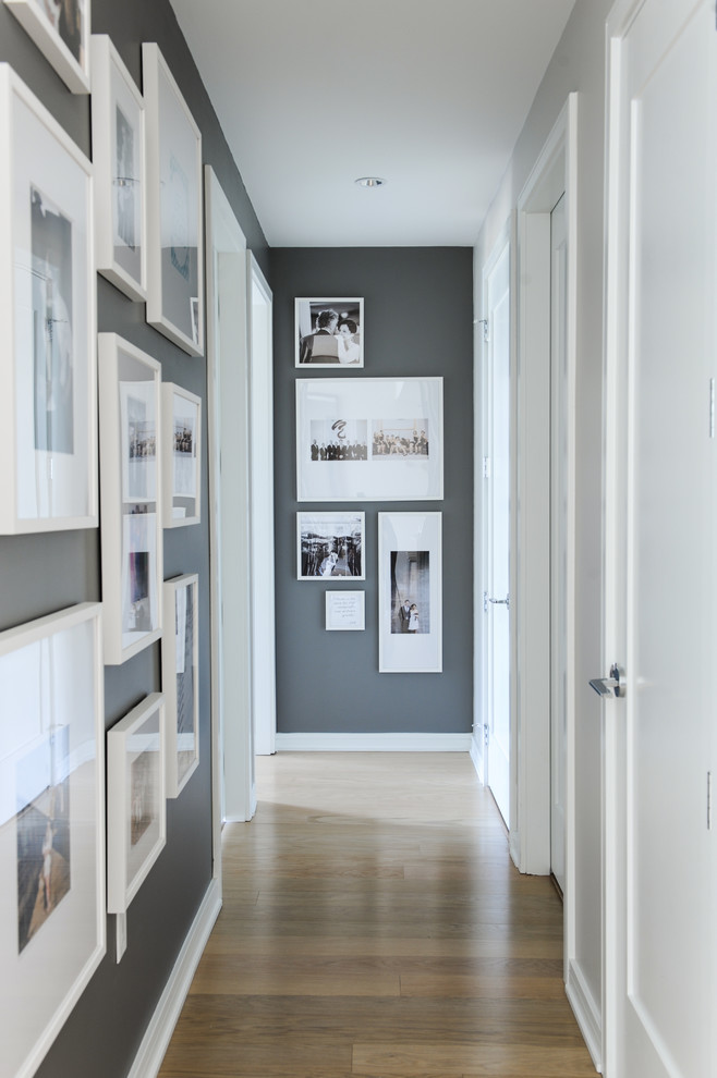 Example of a mid-sized transitional medium tone wood floor hallway design in Vancouver with gray walls