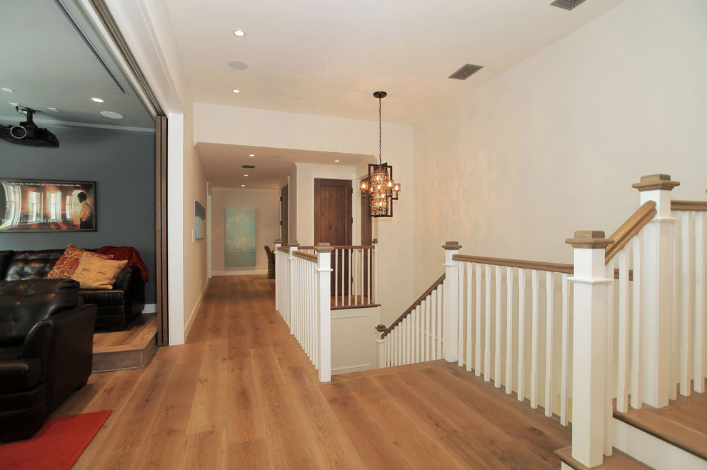 Hallway - large country medium tone wood floor hallway idea in Los Angeles with white walls