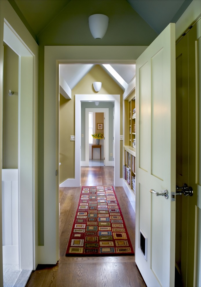 Idée de décoration pour un couloir champêtre avec un mur vert et un sol en bois brun.