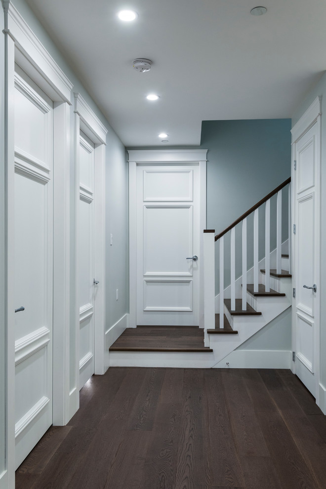 Cette photo montre un petit couloir chic avec un mur gris, parquet foncé et un sol marron.