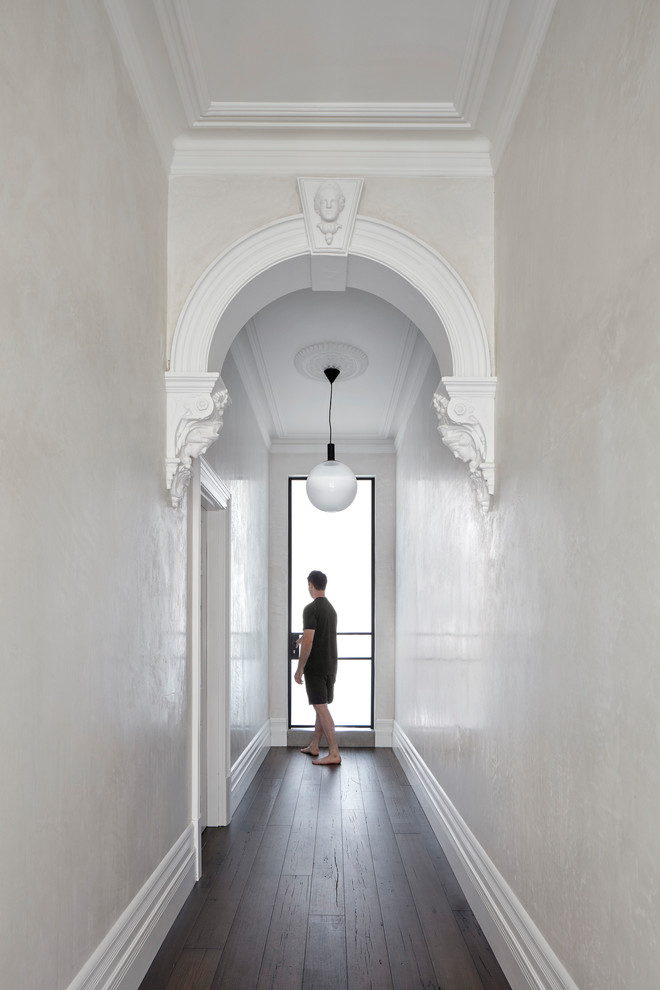 メルボルンにある高級な小さなコンテンポラリースタイルのおしゃれな廊下 (白い壁、濃色無垢フローリング、茶色い床) の写真