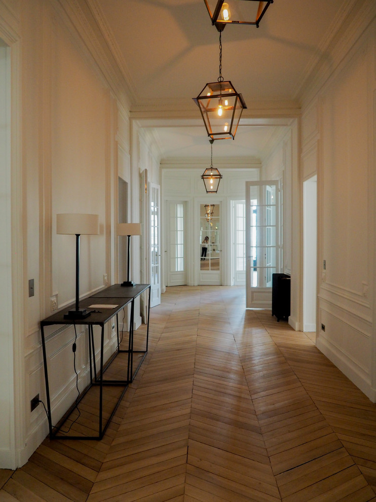 Diseño de recibidores y pasillos clásicos renovados con paredes blancas y suelo de madera clara