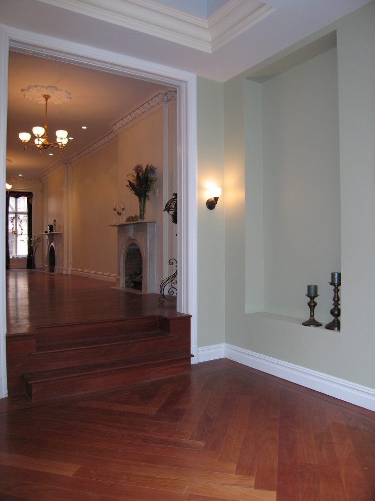 Foto di un ampio ingresso o corridoio chic con pareti verdi e pavimento in legno massello medio