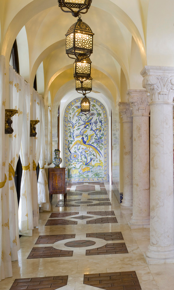 Cette image montre un grand couloir méditerranéen avec un mur beige et un sol en marbre.