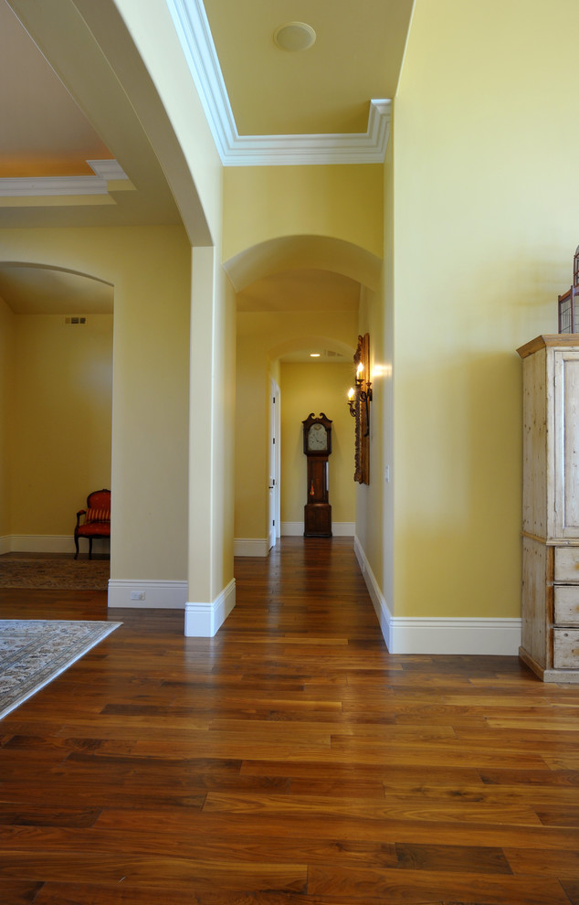 Example of a mid-sized classic medium tone wood floor and brown floor hallway design in Sacramento with yellow walls