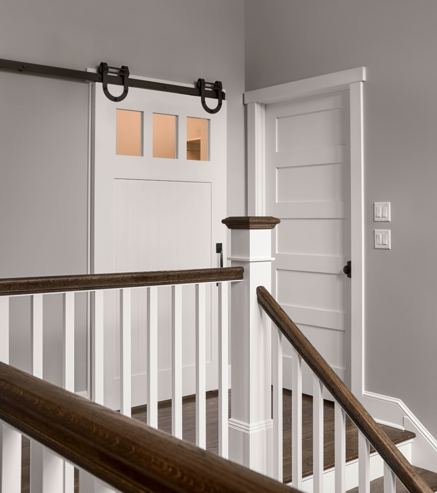 Example of a classic medium tone wood floor hallway design with gray walls