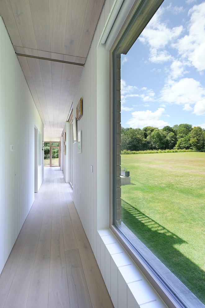 Moderner Flur mit weißer Wandfarbe und hellem Holzboden in Hampshire