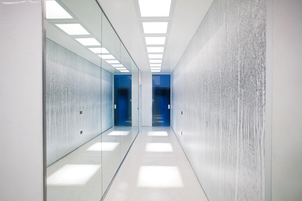 Idée de décoration pour un grand couloir design avec un mur blanc.