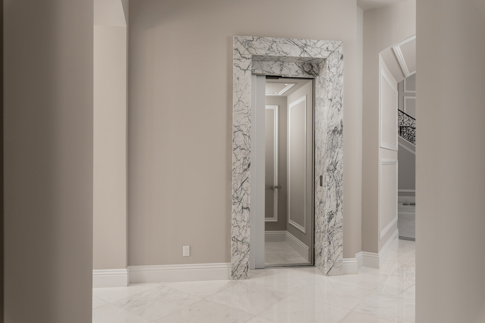 Inspiration pour un très grand couloir minimaliste avec un mur beige, un sol en marbre et un sol blanc.