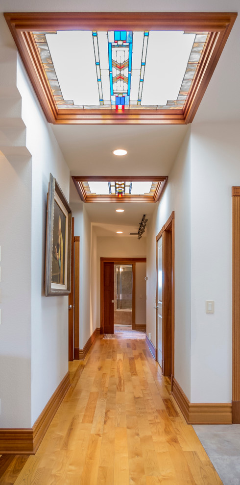 Large arts and crafts light wood floor hallway photo in Other with white walls