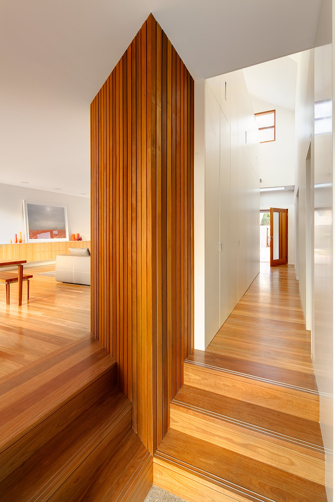 Moderner Flur mit weißer Wandfarbe und braunem Holzboden in Sydney