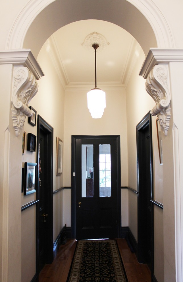 Ejemplo de recibidores y pasillos clásicos de tamaño medio con paredes blancas y suelo de madera en tonos medios