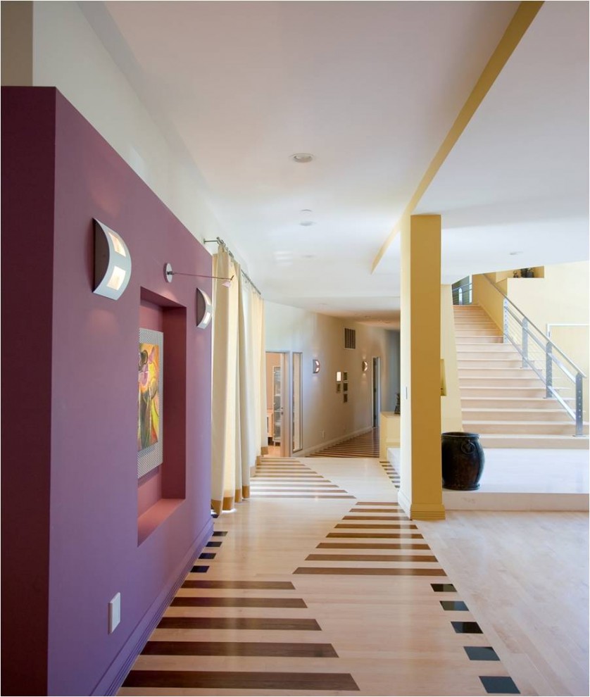Inredning av en modern hall, med lila väggar, ljust trägolv och flerfärgat golv
