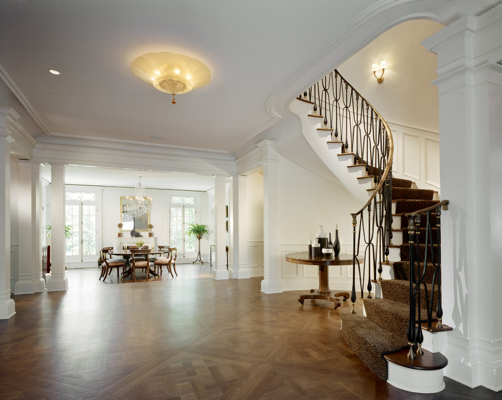 Example of a classic medium tone wood floor hallway design in New York with white walls