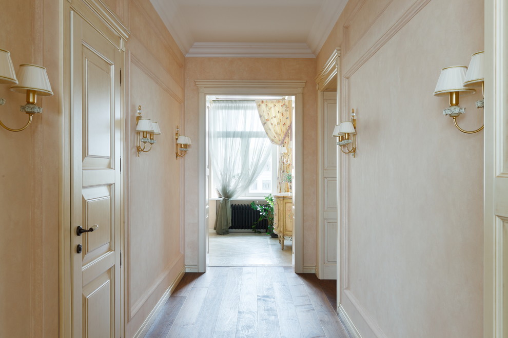 Imagen de recibidores y pasillos tradicionales de tamaño medio con paredes beige y suelo de madera clara