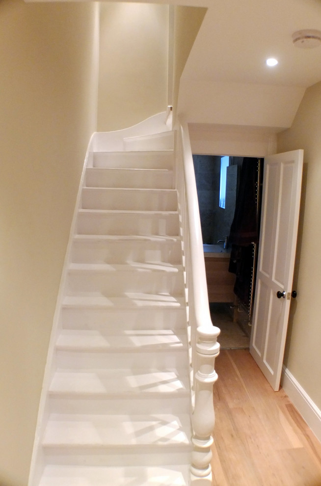 Cette photo montre un petit escalier droit chic avec des marches en bois peint et des contremarches en bois.