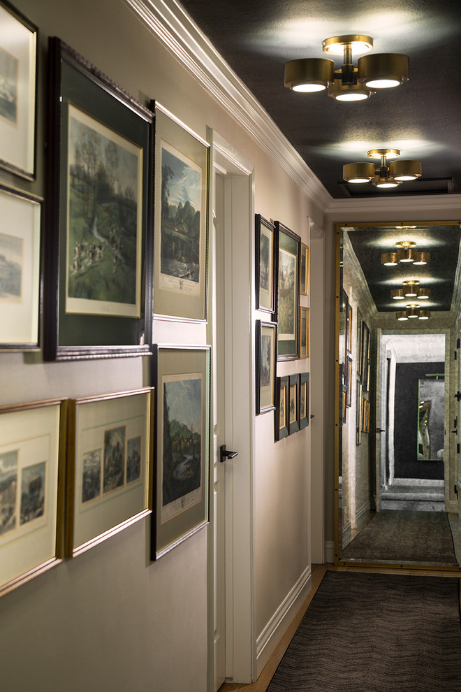 Cette photo montre un couloir éclectique de taille moyenne avec un mur blanc, parquet clair et un sol marron.