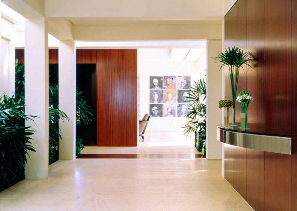 Example of a large trendy limestone floor and beige floor hallway design with multicolored walls