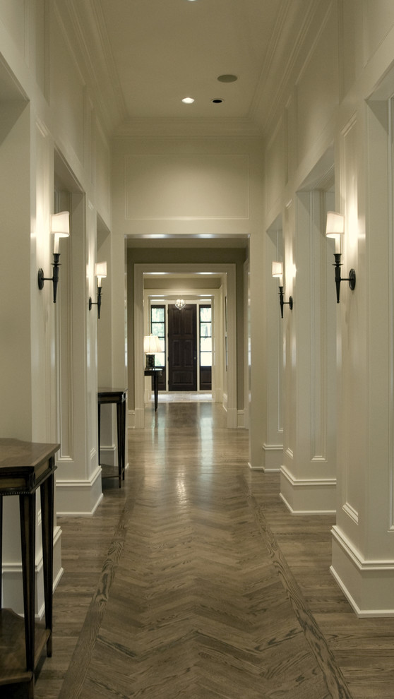 Imagen de recibidores y pasillos clásicos con paredes blancas, suelo gris, suelo de madera clara y iluminación