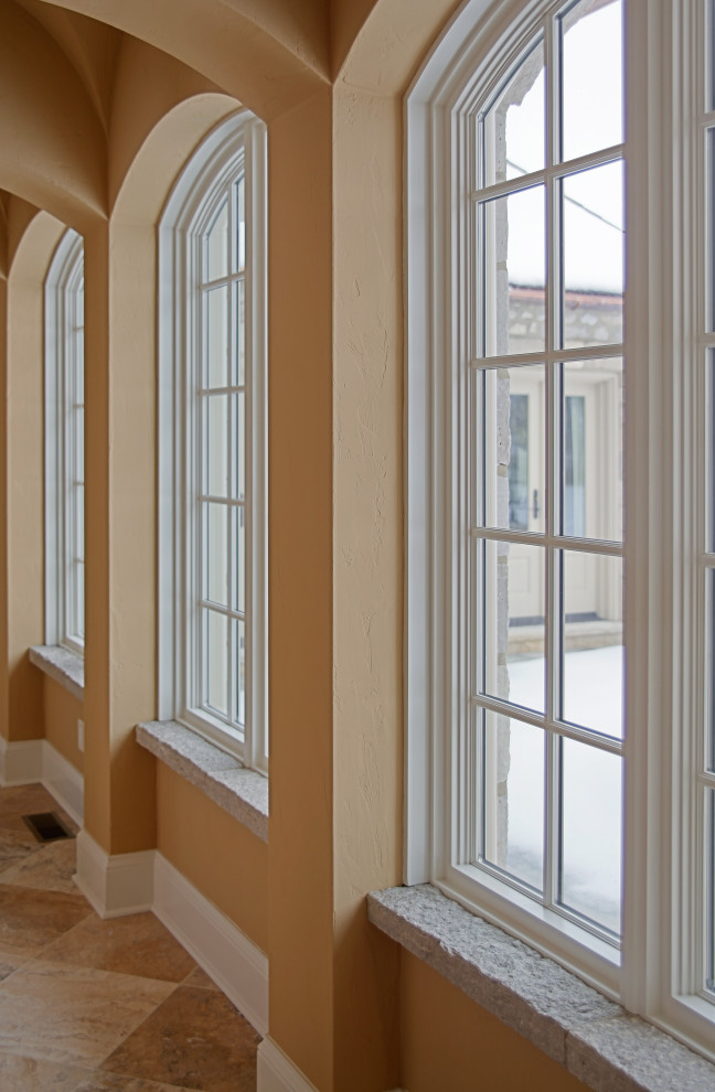 Cette image montre un très grand couloir traditionnel avec un sol en marbre et un plafond voûté.