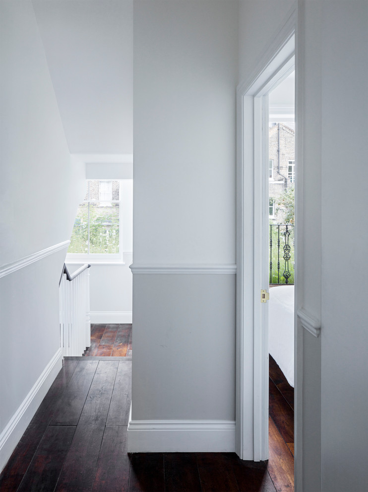Hallway - mid-sized contemporary dark wood floor hallway idea in London with white walls