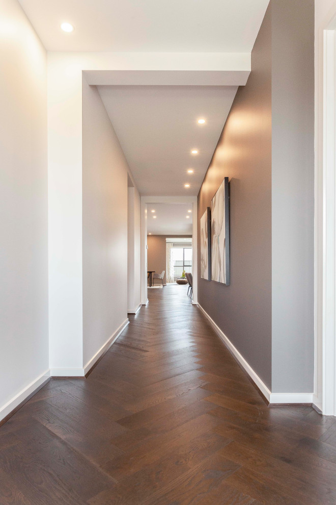 Пример оригинального дизайна: коридор в современном стиле с бежевыми стенами, деревянным полом и коричневым полом