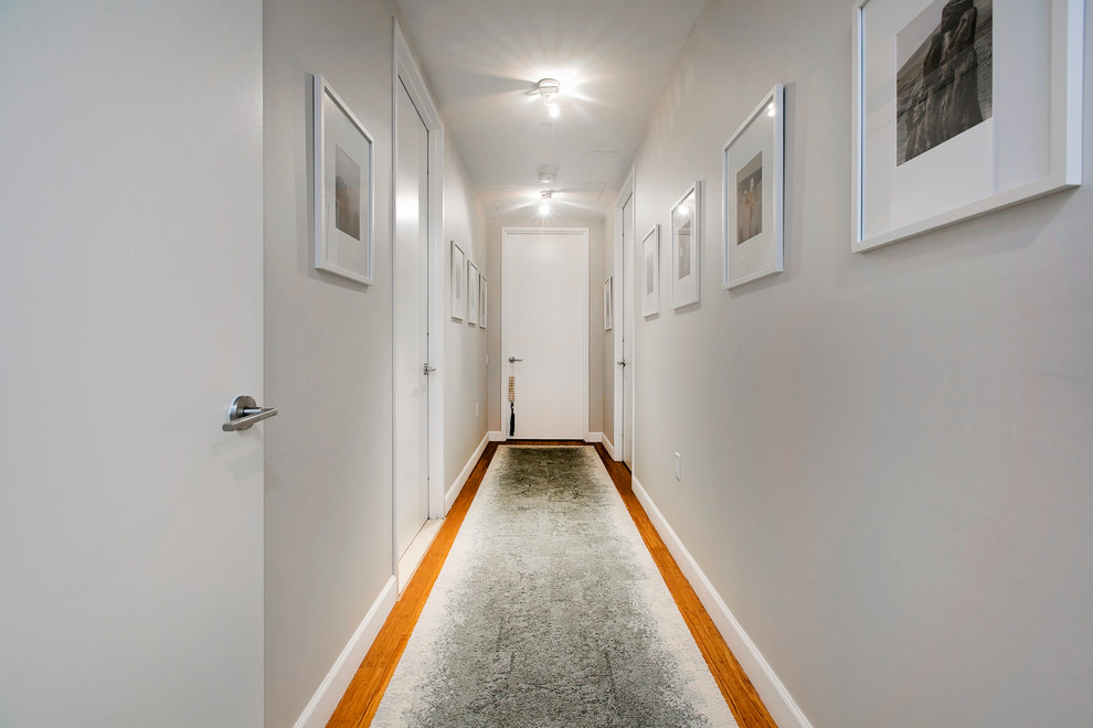 Esempio di un ingresso o corridoio minimal di medie dimensioni con pareti grigie e parquet chiaro