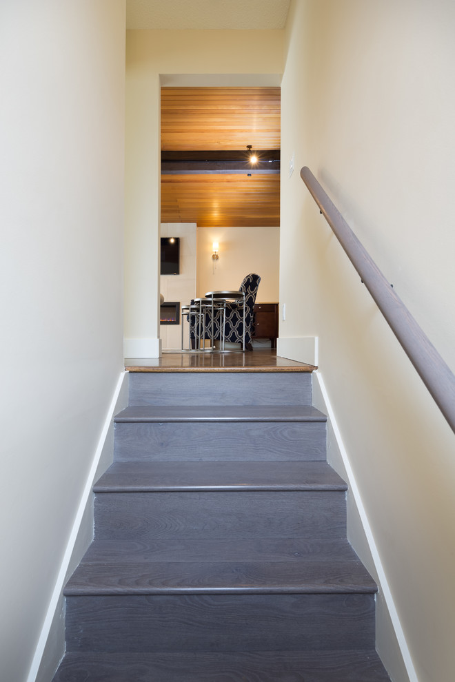 Immagine di un ingresso o corridoio minimalista di medie dimensioni con pareti beige, pavimento in legno massello medio e pavimento marrone