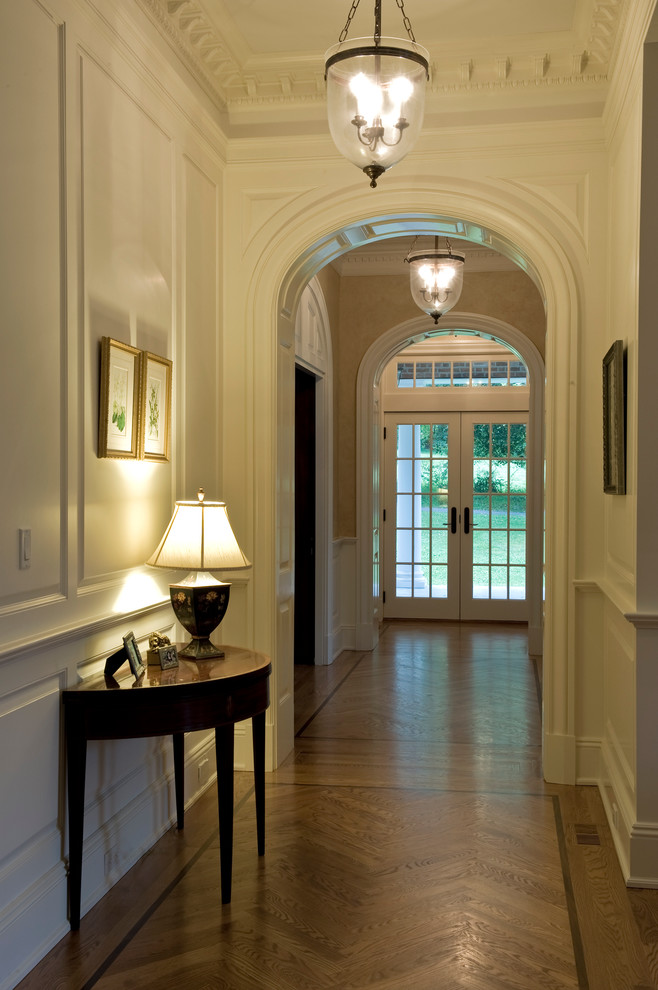 Пример оригинального дизайна: большой коридор: освещение в классическом стиле с светлым паркетным полом и желтыми стенами