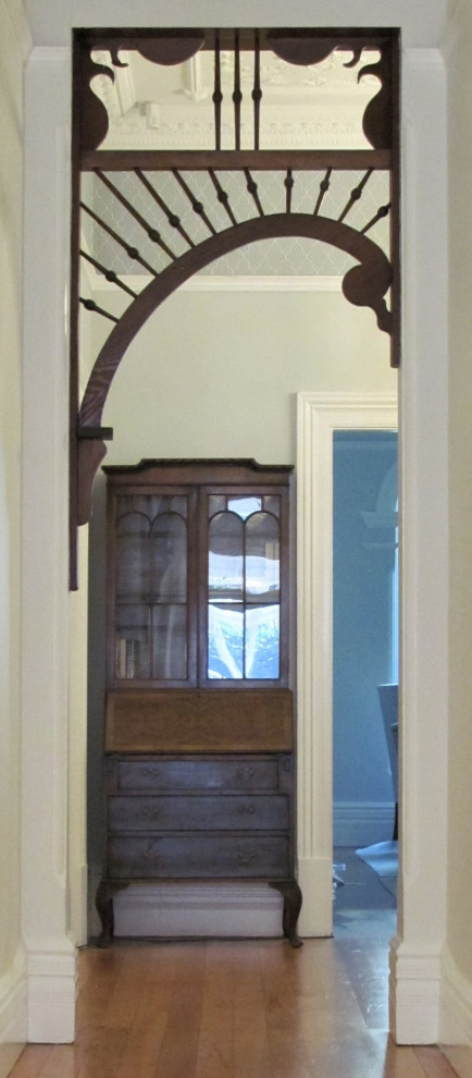 Cette photo montre un grand couloir chic avec un mur blanc, un sol en bois brun, un plafond à caissons et du papier peint.